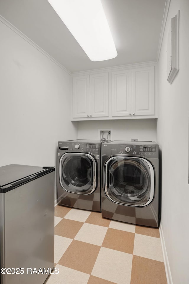 washroom with cabinet space, baseboards, light floors, and washer and dryer