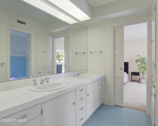 full bath featuring double vanity, ensuite bath, visible vents, and a sink