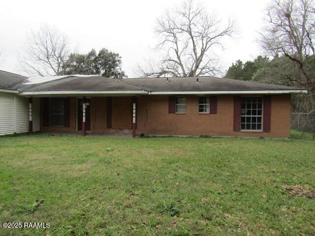 rear view of property with a lawn