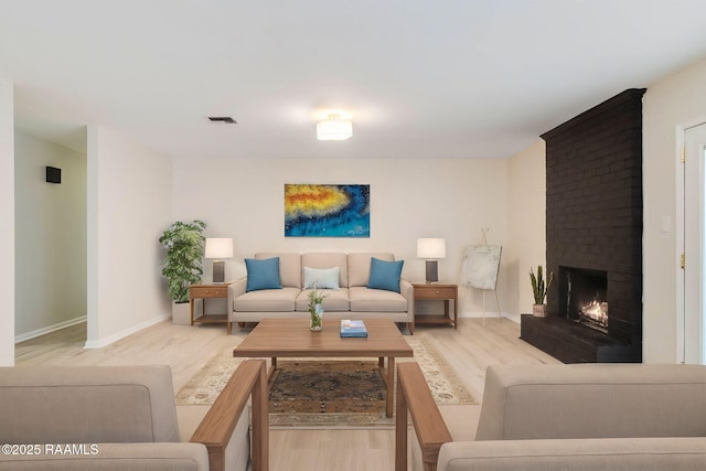 living room with a fireplace and light hardwood / wood-style flooring