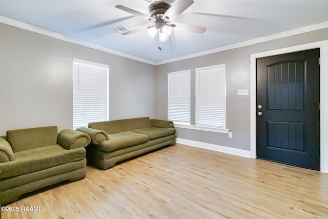 living area with light wood-type flooring, crown molding, baseboards, and ceiling fan