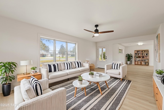 living room with light wood-style flooring and a ceiling fan