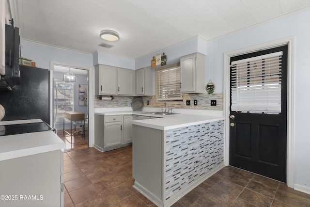 kitchen with light countertops, backsplash, and gray cabinetry