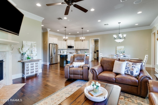 living area featuring dark wood-style flooring, visible vents, a high end fireplace, baseboards, and ornamental molding