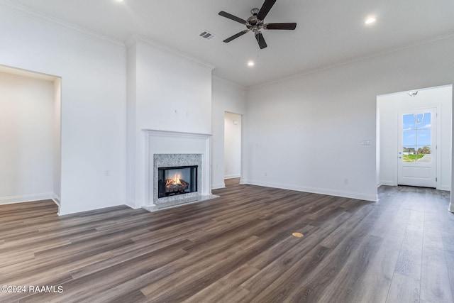 unfurnished living room featuring crown molding, dark hardwood / wood-style floors, ceiling fan, and a high end fireplace