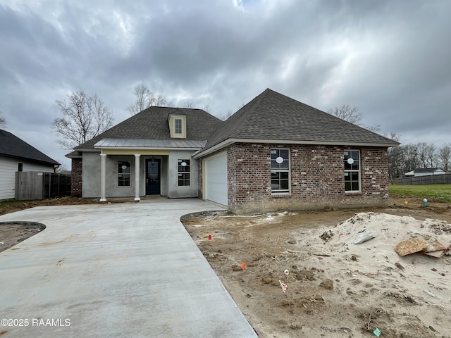 view of front of house with a garage, brick siding, fence, and driveway