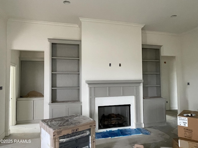 unfurnished living room featuring built in shelves, a tile fireplace, and crown molding