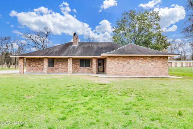 rear view of property with a lawn