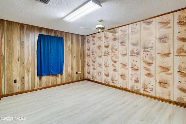 empty room featuring a textured ceiling, hardwood / wood-style floors, and ceiling fan