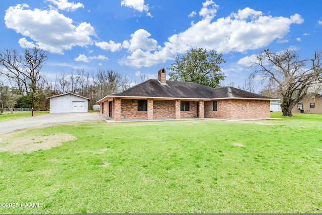 ranch-style home featuring a garage, an outbuilding, and a front yard