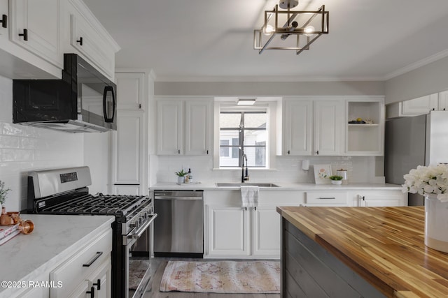 kitchen with stainless steel appliances, butcher block countertops, a sink, white cabinetry, and open shelves