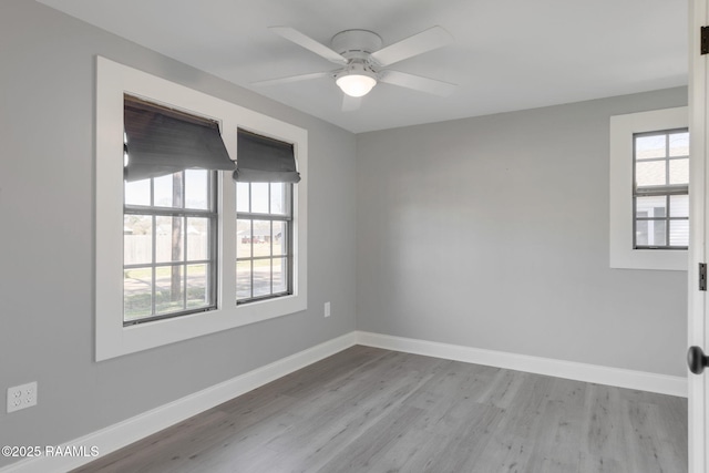 unfurnished room with light wood-style floors, ceiling fan, and baseboards