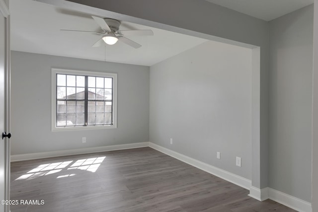 unfurnished room with a ceiling fan, baseboards, and wood finished floors