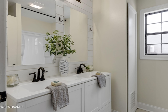 full bathroom with a sink and double vanity