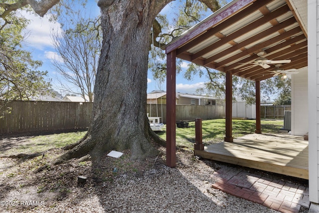 view of yard with a wooden deck, a fenced backyard, and a ceiling fan