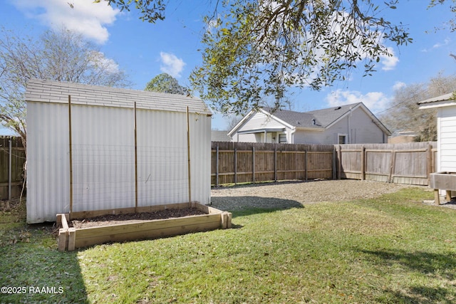 view of yard featuring a storage unit, an outdoor structure, and a fenced backyard