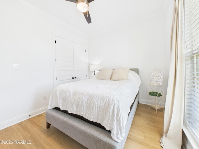 bedroom with a closet, a ceiling fan, baseboards, and light wood finished floors