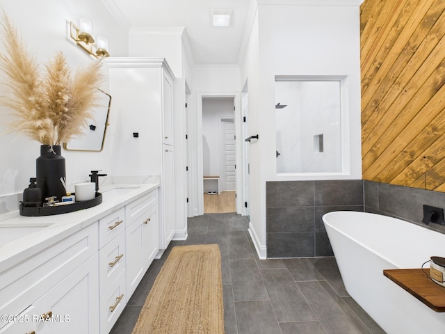 bathroom with a soaking tub, double vanity, ornamental molding, tile patterned flooring, and a sink