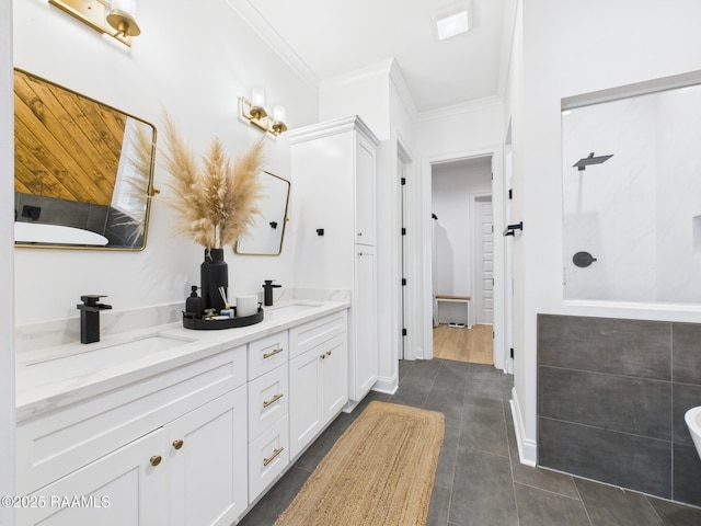 bathroom with a sink, tiled shower, double vanity, and crown molding