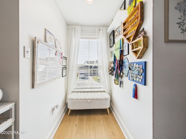 corridor with baseboards and light wood-type flooring