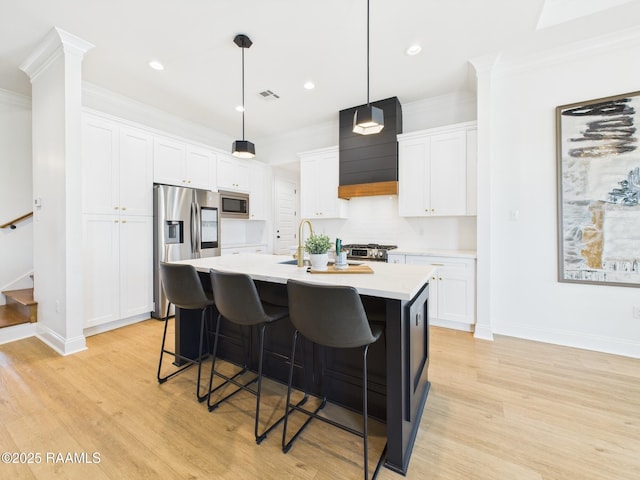 kitchen featuring ornamental molding, stainless steel appliances, a breakfast bar area, light countertops, and custom exhaust hood