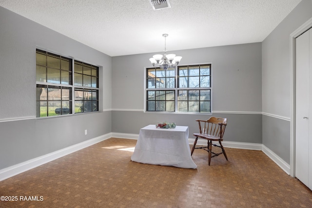 sitting room featuring a chandelier and a textured ceiling