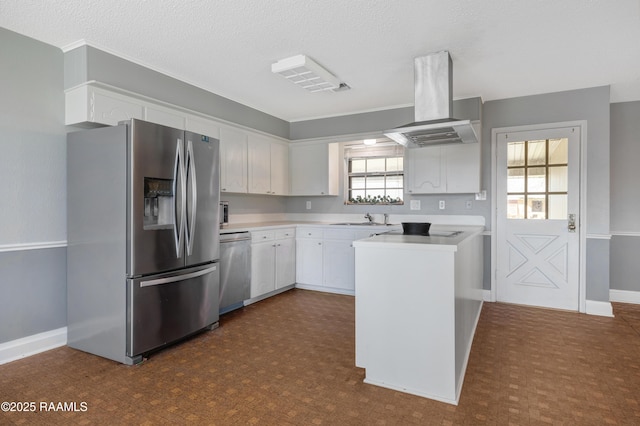 kitchen with appliances with stainless steel finishes, white cabinets, island exhaust hood, sink, and kitchen peninsula