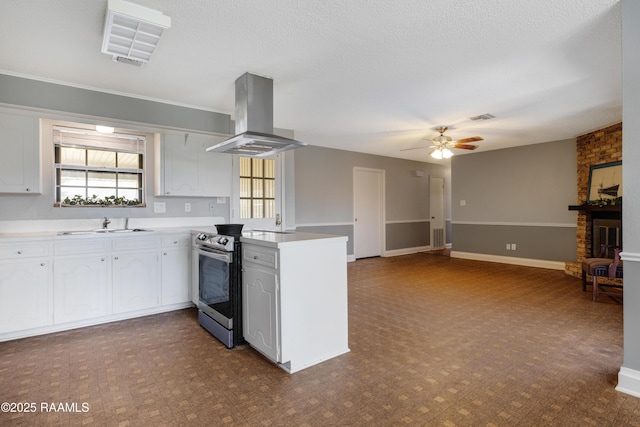 kitchen featuring stainless steel range with electric cooktop, white cabinets, ceiling fan, island range hood, and kitchen peninsula