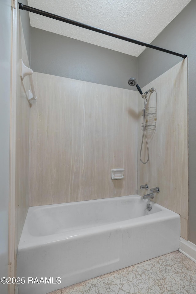 bathroom with tub / shower combination and a textured ceiling