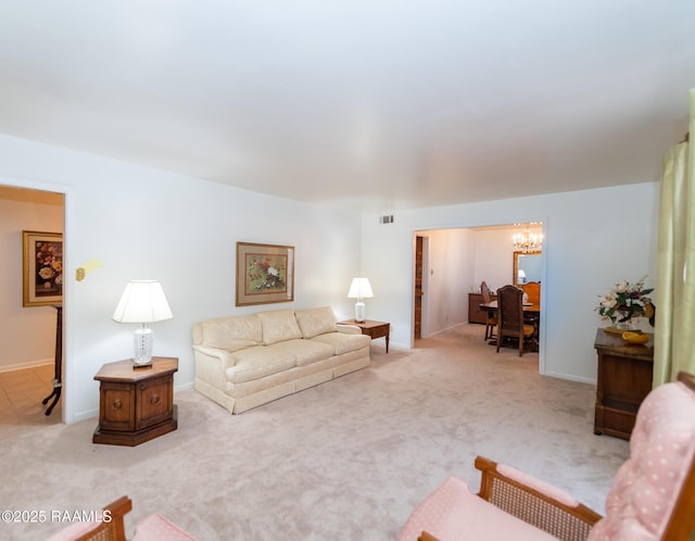 living area featuring an inviting chandelier, light colored carpet, visible vents, and baseboards