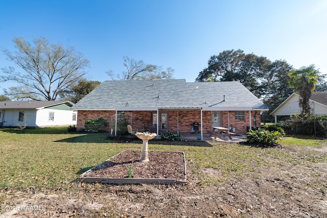 rear view of house with fence, a yard, a patio area, and brick siding