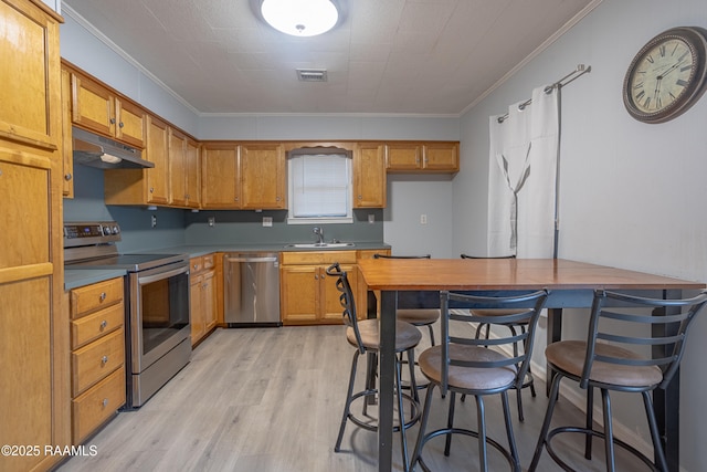 kitchen with stainless steel appliances, a breakfast bar, light hardwood / wood-style flooring, sink, and ornamental molding