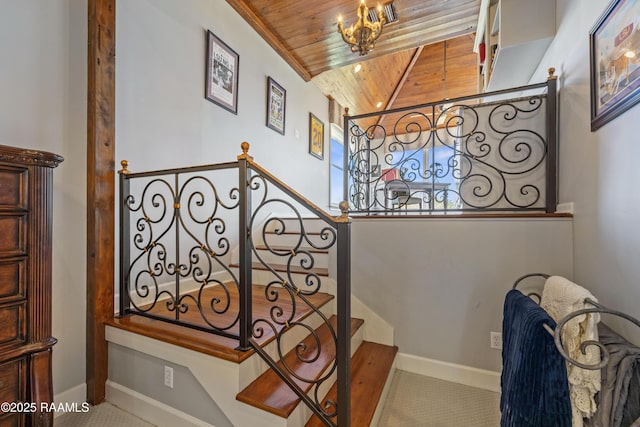 stairway with a chandelier, vaulted ceiling, wooden ceiling, and baseboards