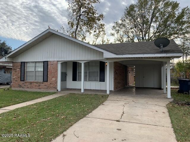 view of front of house with a front lawn and a carport