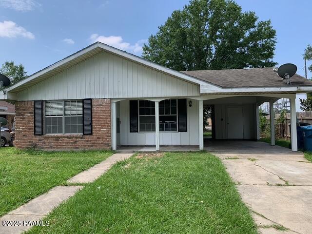 single story home featuring a front lawn and a carport