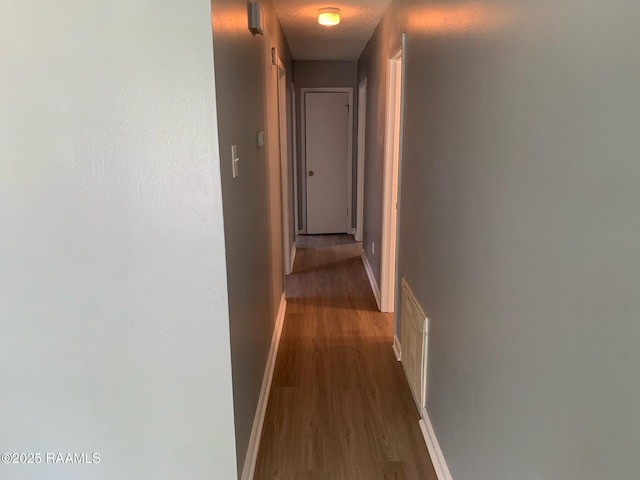 hall with a textured ceiling and hardwood / wood-style floors