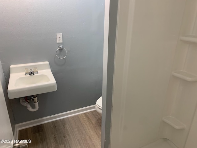 bathroom with hardwood / wood-style flooring, sink, and toilet