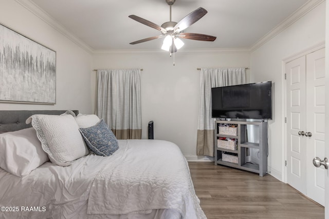 bedroom featuring ceiling fan, ornamental molding, wood finished floors, and baseboards