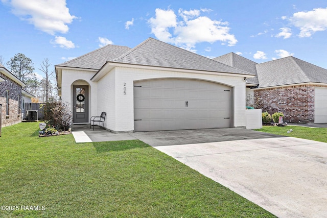 french country style house featuring concrete driveway, roof with shingles, an attached garage, a front lawn, and brick siding