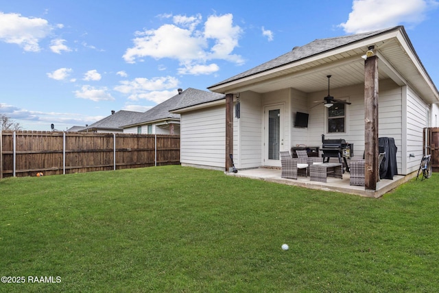 back of property featuring a yard, a fenced backyard, ceiling fan, and a patio