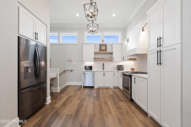 kitchen with appliances with stainless steel finishes, decorative light fixtures, light countertops, premium range hood, and open shelves