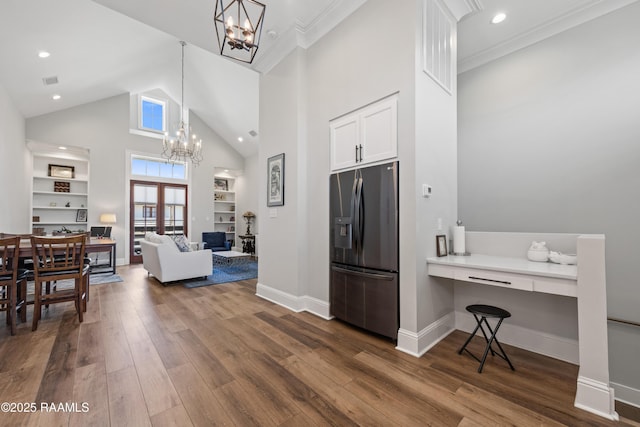 kitchen featuring light countertops, open floor plan, white cabinetry, refrigerator with ice dispenser, and a chandelier