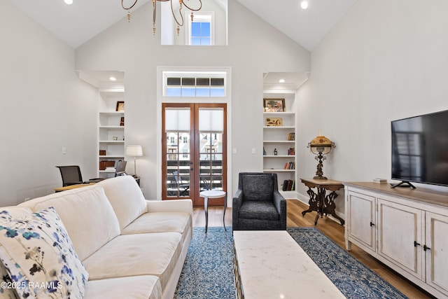 living area with built in shelves, french doors, recessed lighting, wood finished floors, and high vaulted ceiling