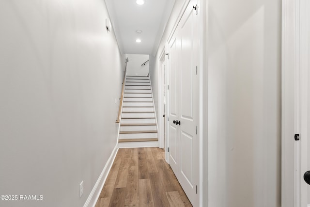 corridor featuring light wood-style floors, recessed lighting, stairway, and baseboards