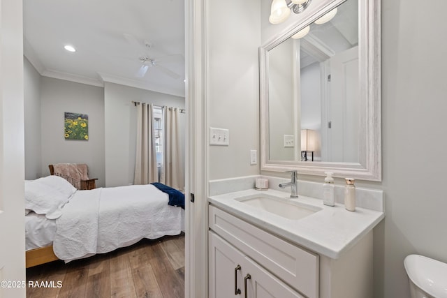 interior space featuring recessed lighting, wood finished floors, a sink, a ceiling fan, and ornamental molding