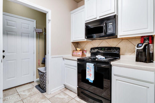 kitchen featuring light countertops, backsplash, white cabinets, light tile patterned flooring, and black appliances