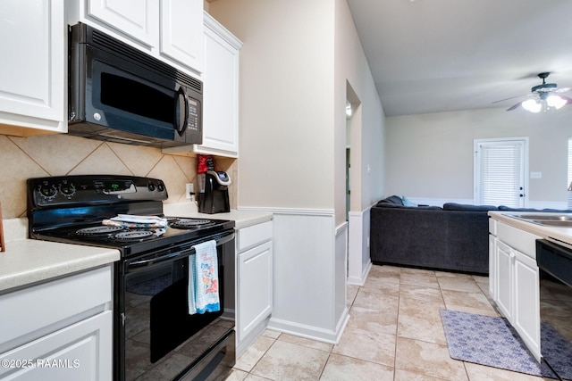 kitchen with white cabinets, black appliances, open floor plan, and light countertops