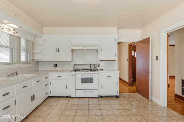 kitchen featuring white range with gas cooktop, a sink, open shelves, backsplash, and light countertops