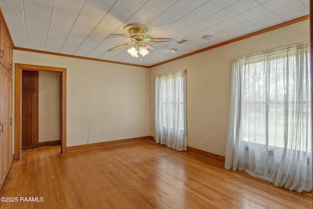 unfurnished bedroom featuring visible vents, a ceiling fan, crown molding, light wood finished floors, and baseboards