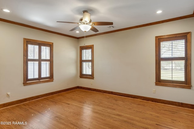 spare room featuring ceiling fan, baseboards, light wood finished floors, and ornamental molding